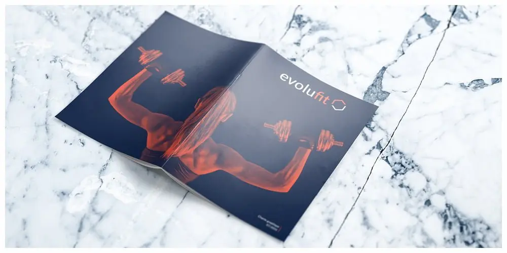 Brochure Evolufit ouverte sur marbre, identité visuelle de salle de sport