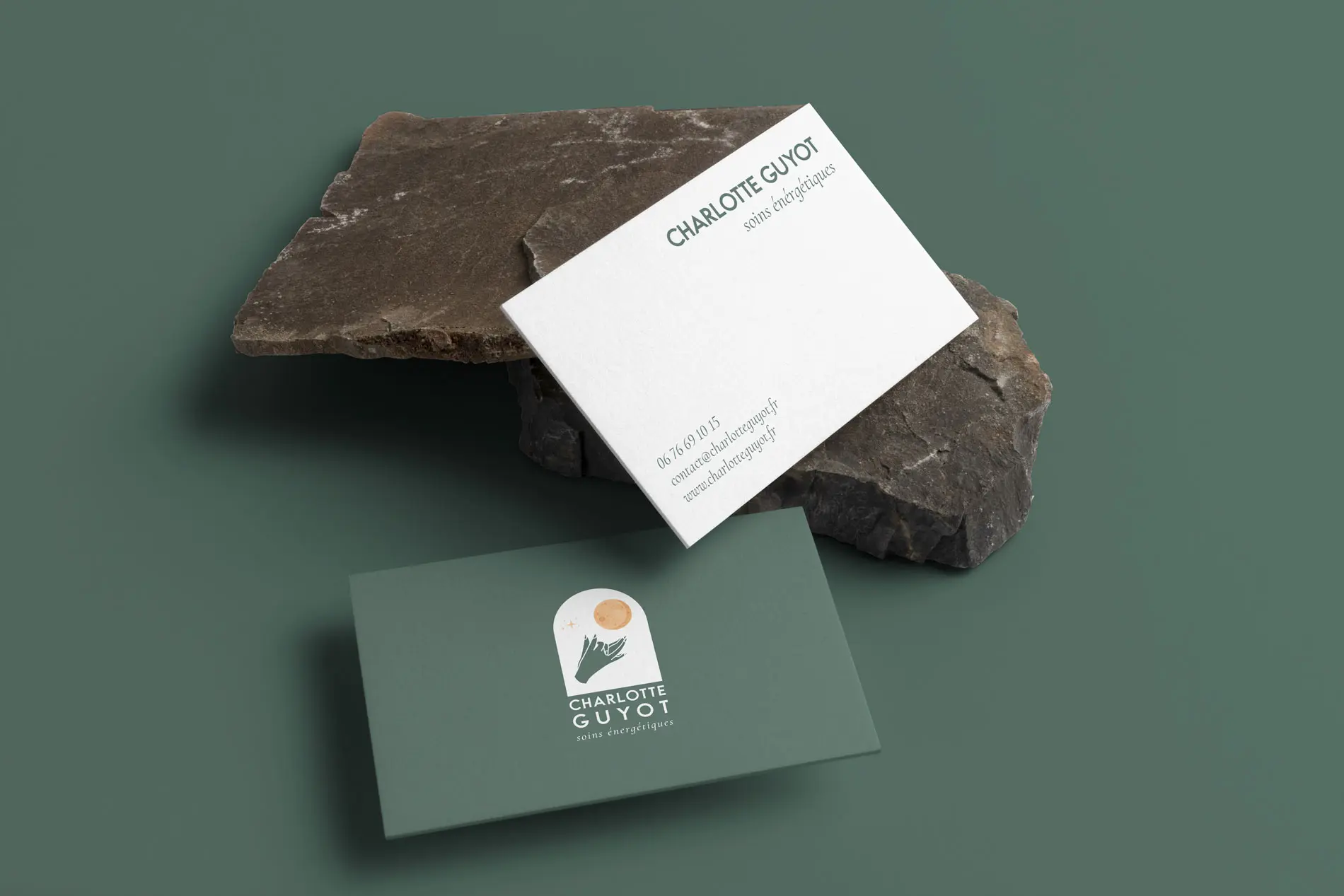 Cartes de visite Charlotte Guyot, soins énergétiques, posées sur une pierre