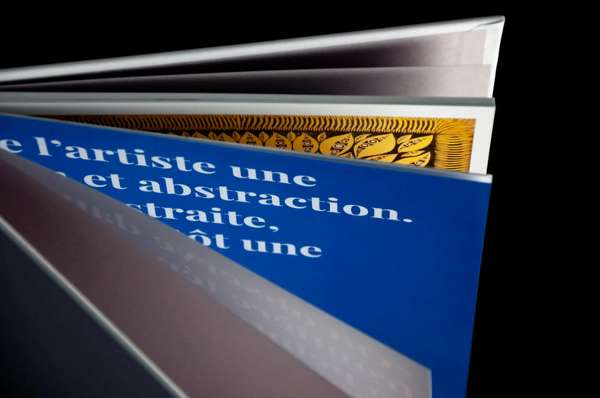Pages intérieures du livre d'art Rachid Boukharta, texte blanc sur fond bleu