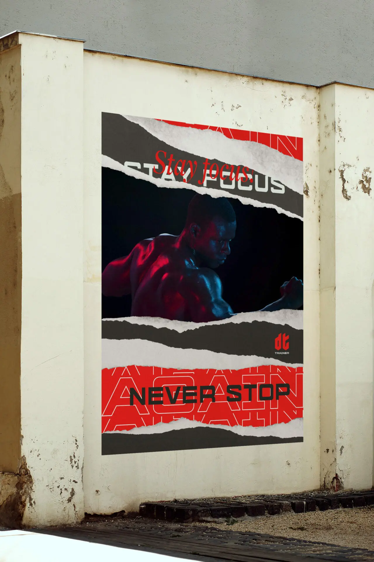 Affiche DT Trainer sur un mur extérieur, avec une photographie de sportif et des textes blancs, noirs et rouges.
