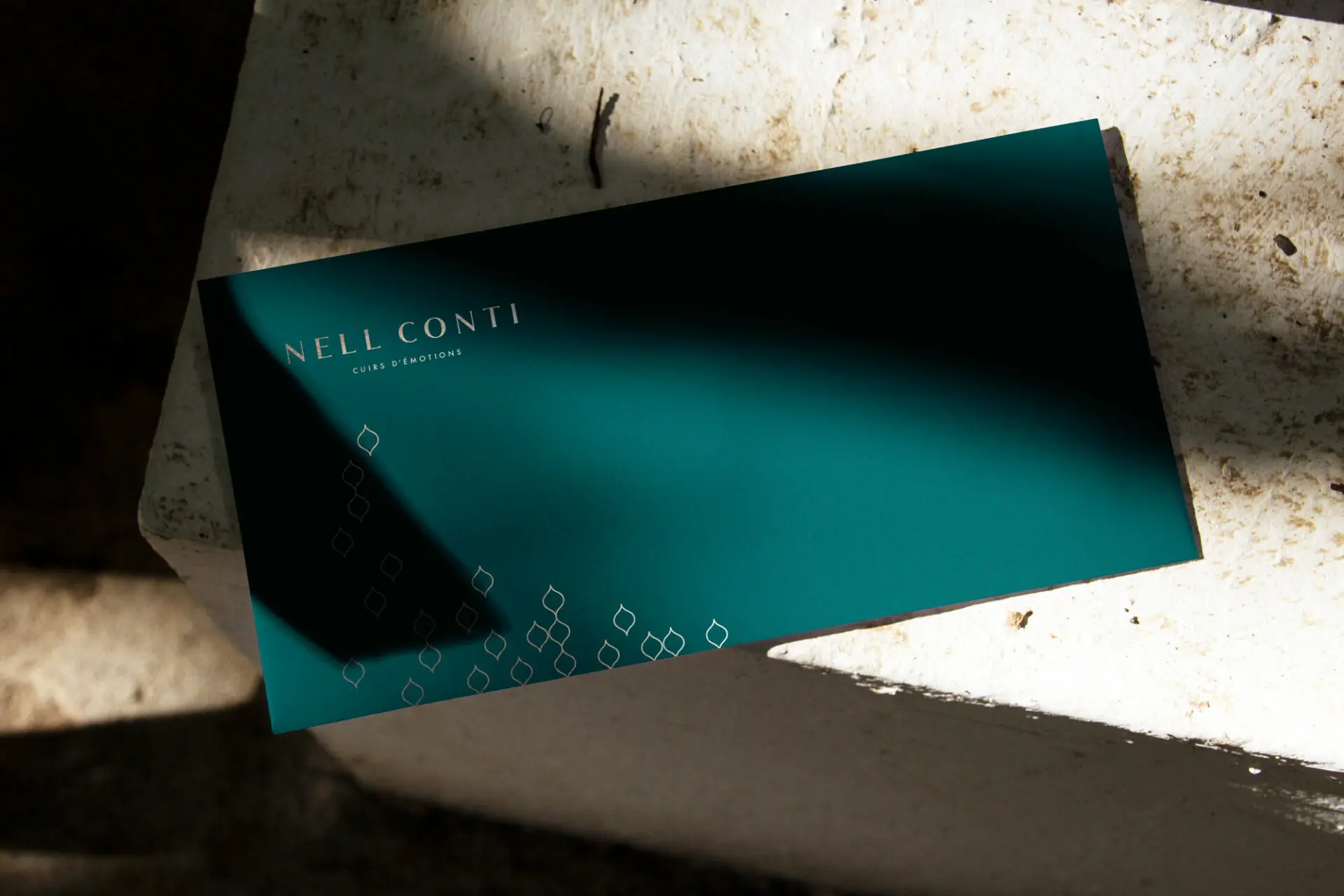 Envelope-Mockup-(2) Enveloppe vert émeraude Nell Conti posée sur la pierre, jeu d'ombres