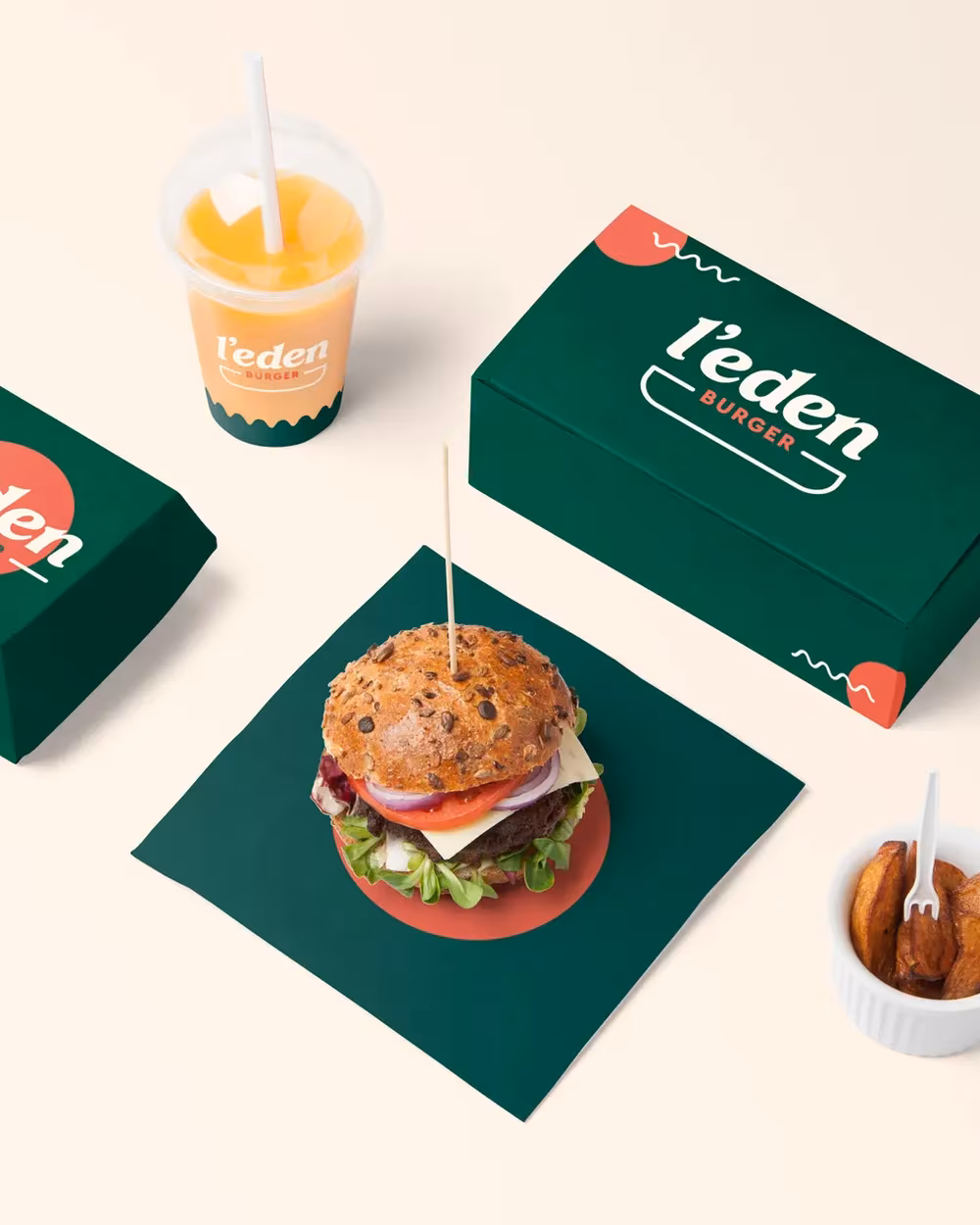 Packaging vert et crème de L'Eden Burger avec burger et boisson