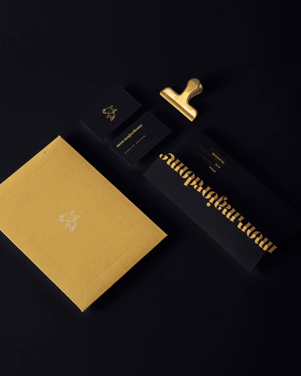 Pochette dorée et papeterie noire de l'identité Mon Majordome
