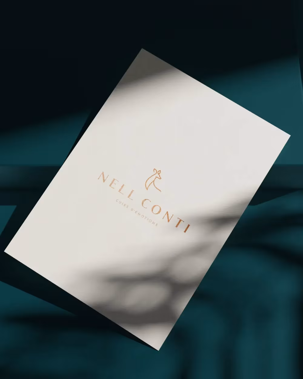 Carte Nell Conti posée sur un cuir turquoise sombre, identité visuelle d'une maison de cuirs parfumés