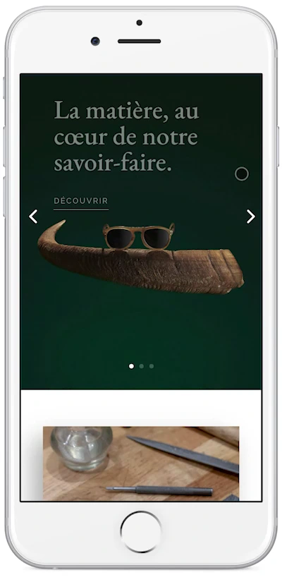 Capture de l’accueil mobile Ateliers Baudin dans un téléphone blanc, avec une monture posée sur une corne et le début de la présentation du savoir-faire.